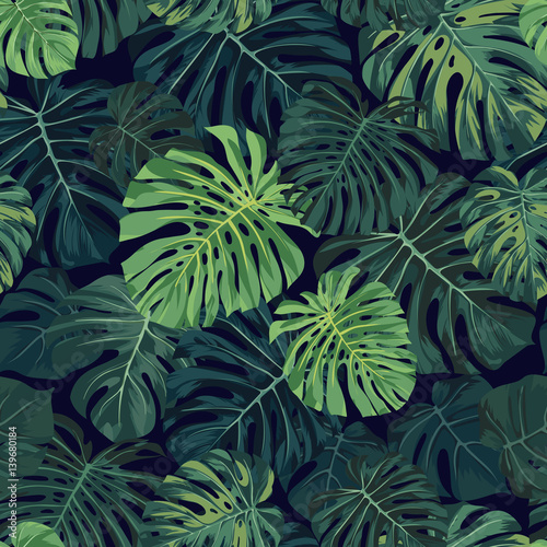 Naklejka ścienna Seamless vector tropical pattern with green monstera palm leaves on dark background. Exotic hawaiian fabric design.