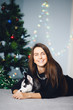© Parilov - Girl on the background of a Christmas tree with a puppy of a husky. Dog black and white with blue eyes. Concept gift for the new year dog.