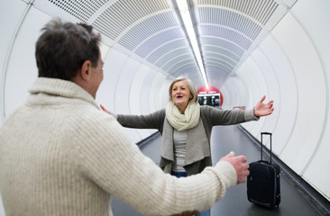 Wall Mural - Senior couple in hallway of subway greeting