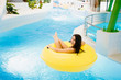 © Parilov - Beautiful girl has a rest on inflatable ring in the water park. smiling