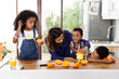 © Lisa Tichané - Famille qui prépare du jus d'orange dans la cuisine