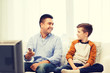 © Syda Productions - smiling father and son watching tv at home