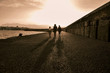 © GIORGOS - long shadows of people walking along the Venetian fortress of Koule at Heraklion port at sunset time.