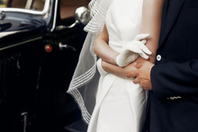 Elegant Gorgeous Bride And Stylish Handsome Groom Holding Hands Close Up, Gentle Touch. Unusual Luxury Wedding In Retro Style. Amazing Romantic Moment