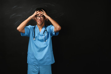 Wall Mural - Young handsome medical student on blackboard background