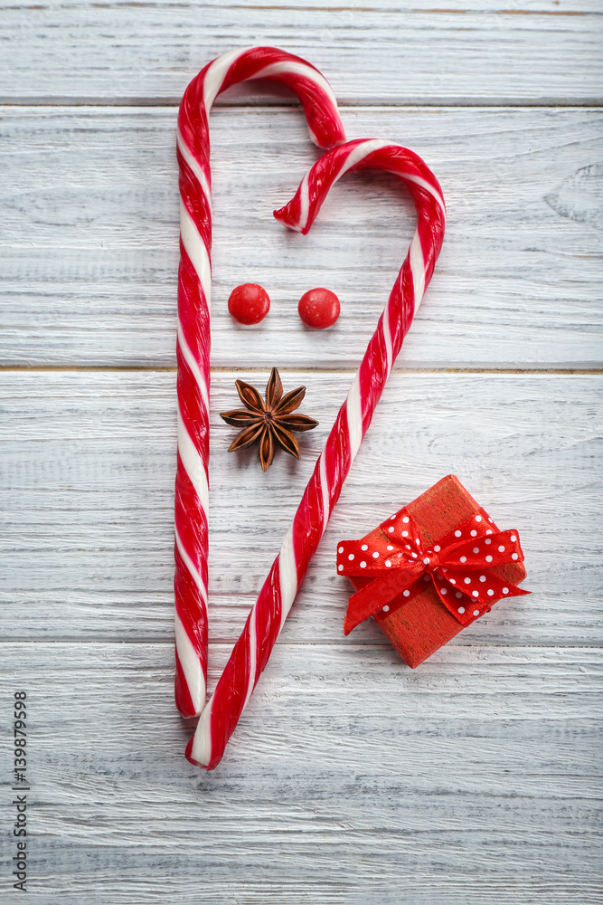Composition with Christmas candy canes on white wooden table