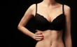 © Africa Studio - Young woman in bra on black background