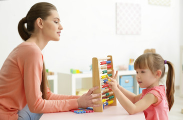 Wall Mural - Cute little girl learning to count at private teacher's office