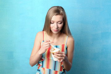 Poster - Beautiful young woman with ice cream on color background