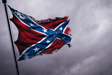 Closeup Of Ripped Tear Grunge Old Waving Confederate Flag Of The National States Of America Us, Fabric Texture American Symbol On Cloudy Sky, Dark Mystery Style Atmosphere