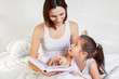© Shcherbakova - young mother and child reading a book in bed