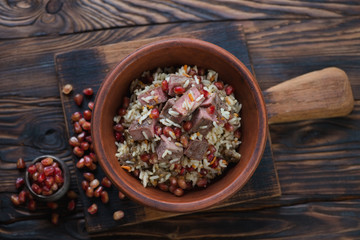 Wall Mural - Ceramic bowl with pilaf on a rustic wooden background, view from above