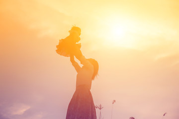 Happy Mother with baby sunset.