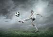 © Andrii IURLOV - Football player with ball in action under sky with clouds