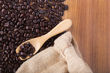 Canvas Print - coffee beans on wooden spoon with burlap on table