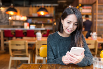 Wall Mural - Woman working on cellphone in coffee  shop