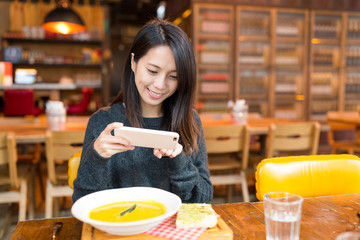 Poster - Woman taking photo on her dish in restauarant