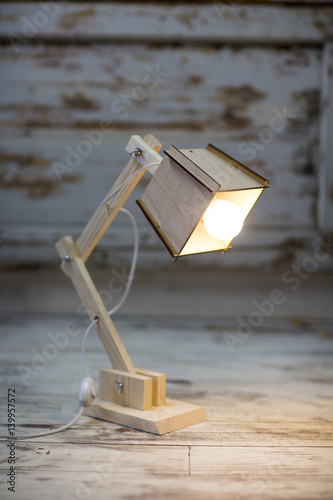Fotomural Homemade wooden table lamp on a background of cracked paint vintage wall