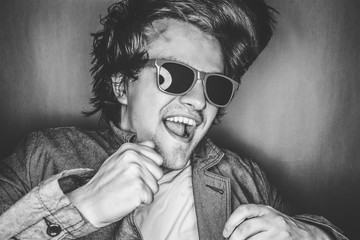 closeup portrait of a casual young man with sunglasses jumping