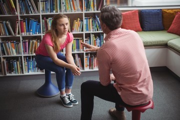 Teacher interacting with student in library