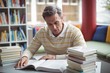© WavebreakMediaMicro - Attentive school teacher reading book in library