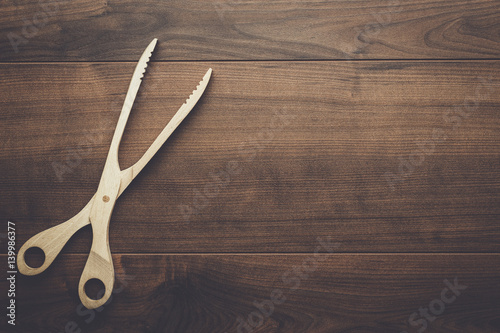 Fotomural wooden grill tongs on the brown table