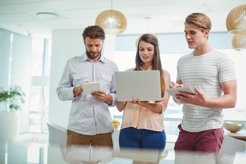 Wall Mural - Attentive executives using digital tablet and laptop