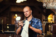 © bondvit - Barman at work in pub,Portrait of cheerful barman worker standing,Waiter giving menus,A pub.Bar.Restaurant.Classic.Evening.European restaurant.European bar.American restaurant.American bar.