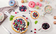 Sweet desserts with fresh berries on  white wooden table. Top view