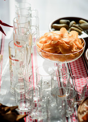 Wall Mural - Potato chips served in glass bowl stand among empty glasses