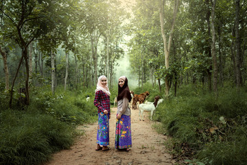 Wall Mural - Women dressed in traditional Muslim dress Goat work in the wild North of Thailand and South