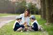 © Tomsickova - Young mother and her two children, boys, playing with little baby chicks in cherry blossom garden