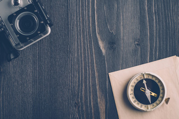 Wall Mural - Old compass and camera on a dark wooden background