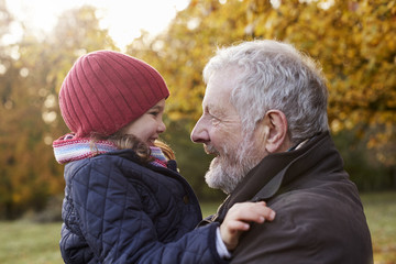 Wall Mural - Grandfather Cuddling Granddaughter On Autumn Walk