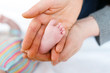 © Irina Schmidt - Father or mother holding foot of newborn baby