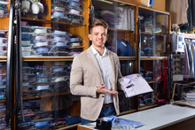 Male Seller Demonstrating Shirts In Men’s Cloths Store