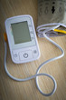 © hriana - Digital blood pressure meter on wooden table with blank monitor