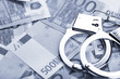 Pair of handcuffs closeup on euro banknotes background