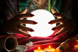 Fototapeta  - Hands of an female fortune teller around a crystal ball