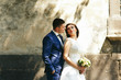 © syrotkin - Shadows of trees lie on the wall before which stands luxury wedding couple