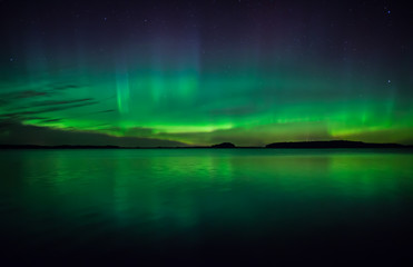 northern lights dancing over calm lake
