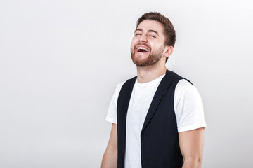 Wall Mural - portrait of young attractive smiling man in white shirt on gray background.