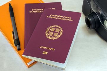 two passports, a camera and an orange notebook.