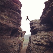 Person In Mid Air, Leaping In Between Cliffs 