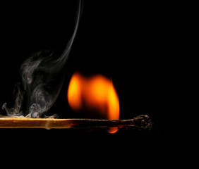 Macro fire burning on matchstick. Studio shot isolated on black