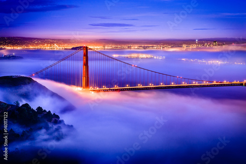 Vászonkép Golden Gate Bridge at dawn surrounded by fog from Marin Headlands in San Francis
