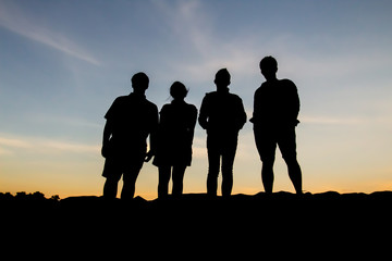 Silhouette of people posting during sunset