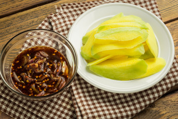 Wall Mural - Mango-with-sweet-fish-sauce on wood table.