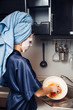 © Parilov - The girl washes the dirty dishes with a frying pan in a nourishing mask on the skin. Mask for rejuvenating and eliminating skin defects. Acne