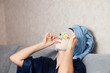 © Parilov - The girl puts and corrects a nutritious mask on a skin with green ripe fresh cucumber. Mask for rejuvenating and eliminating skin defects. Acne, acne.